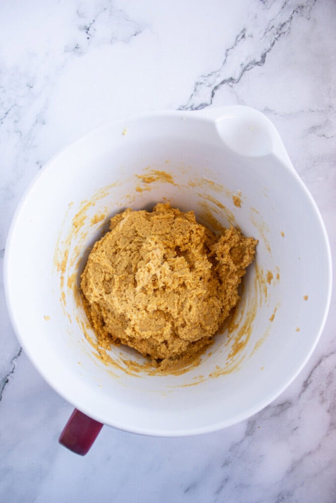 Bowl of cookie dough placed on a marble countertop.