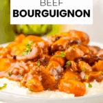A plate of slow cooker beef bourguignon with carrots and sauce, garnished with parsley, served on mashed potatoes. Text reads "Slow Cooker Beef Bourguignon.