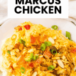 A plate of creamy Neiman Marcus Chicken casserole topped with sliced almonds and chopped green onions.