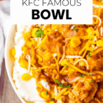 A bowl of mashed potatoes topped with fried chicken pieces, corn, shredded cheese, gravy, and parsley. The text reads "Copycat KFC Famous Bowl.