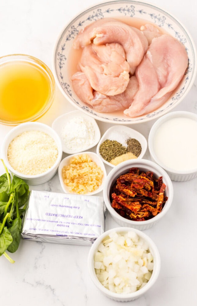 Raw chicken, broth, cream cheese, spinach, sun-dried tomatoes, onions, garlic, seasonings, and grated cheese.