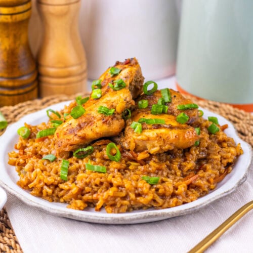 Japanese BBQ chicken with golden fried rice garnished with scallions, plated and ready to serve