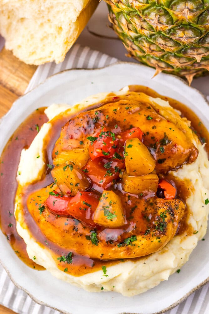 Slow cooker sweet chili pineapple chicken served on mashed potatoes with fresh pineapple and bread
