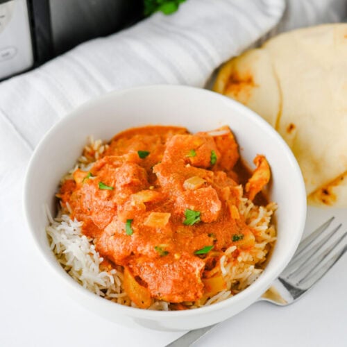 Slow cooker chicken tikka masala with rice and naan bread served in white bowl
