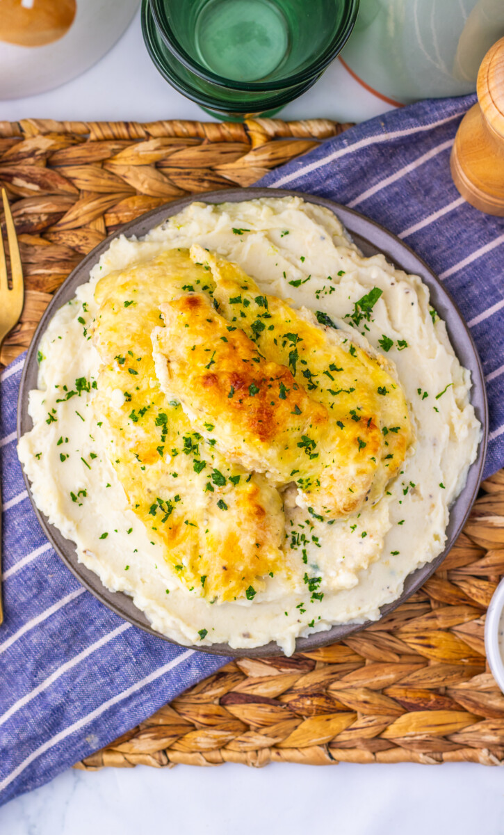 Creamy chicken caesar bake with golden melted cheese and fresh chives garnish on white plate