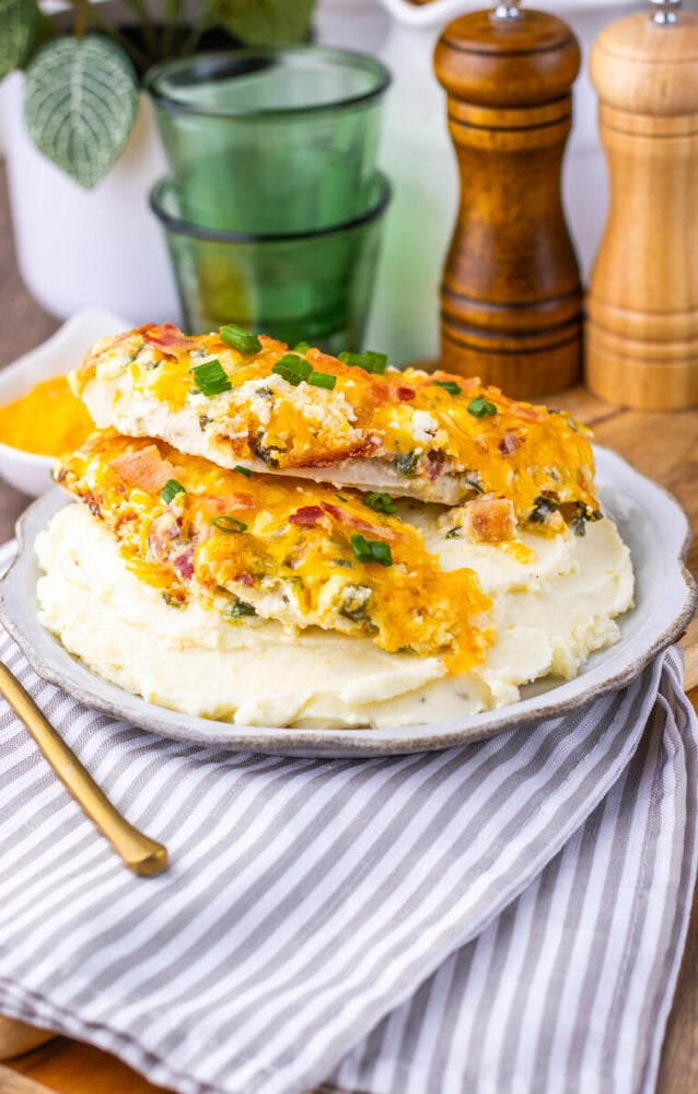 Million Dollar Baked Chicken Breasts with cheddar cheese and green onions on mashed potatoes