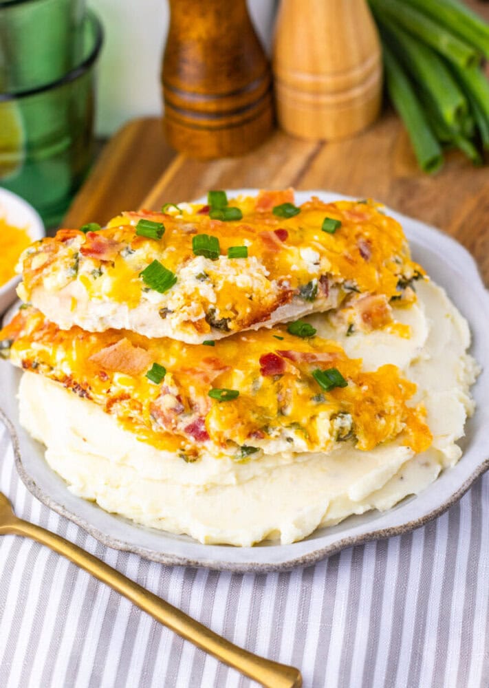 Million Dollar Baked Chicken Breasts with cheese, bacon, and green onions on mashed potatoes