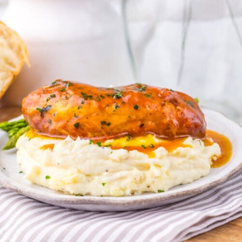 Slow cooker apricot brown sugar chicken with mashed potatoes and asparagus plated on white dish