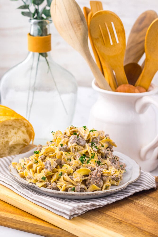 Slow cooker creamy ranch beef and noodles served in a white bowl, garnished with parsley
