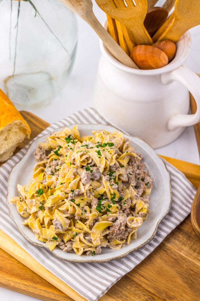 Slow cooker creamy ranch beef and noodles plated on white dish with parsley garnish