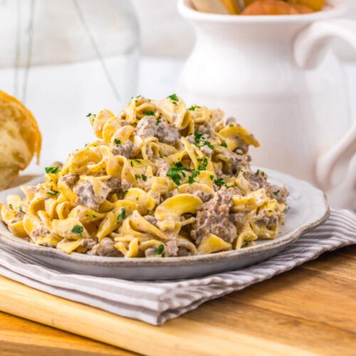 Slow cooker creamy ranch beef and noodles plated on gray dish with fresh parsley garnish