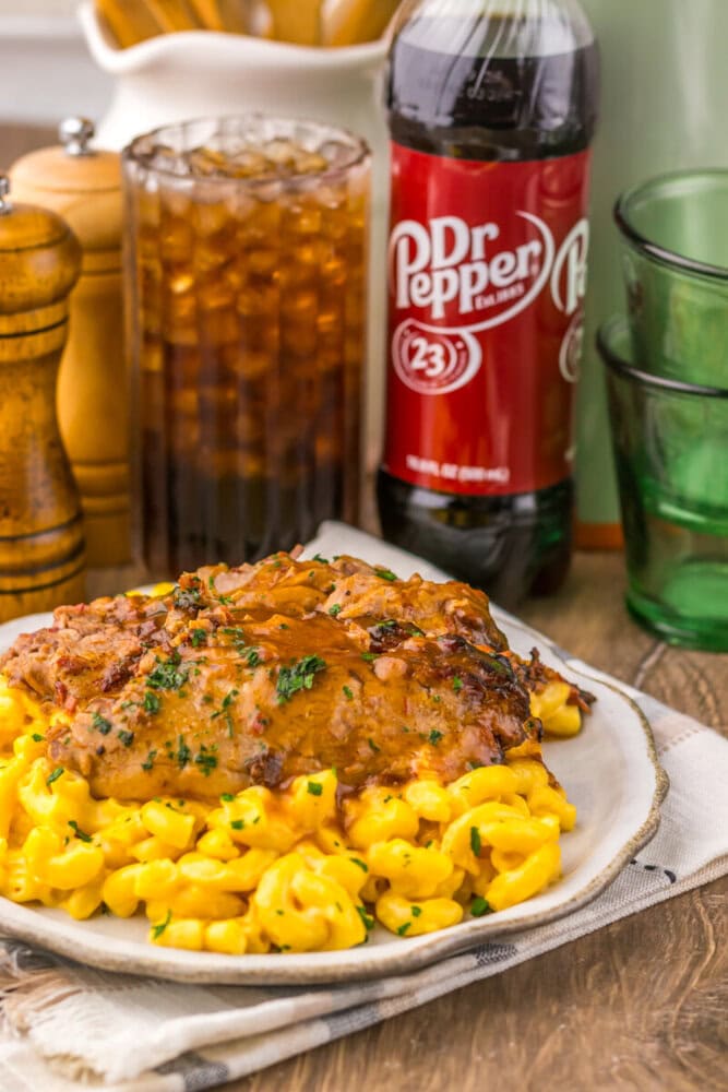 Slow Cooker Dr Pepper BBQ Brisket plated with corn and garnished with parsley, served with Dr Pepper beverage