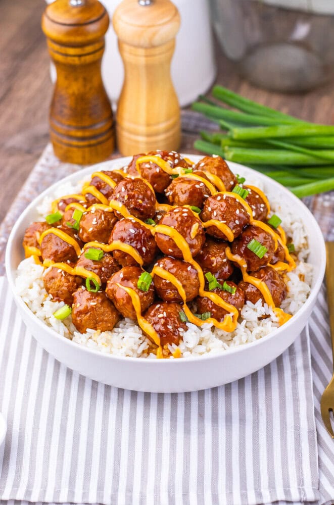 Slow cooker Korean BBQ meatballs with sesame seeds and green onions served over rice