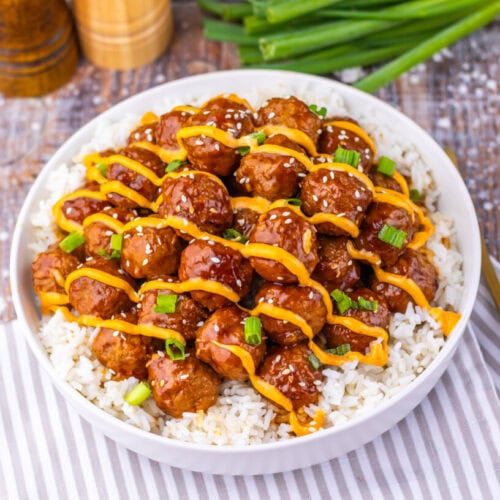 Slow cooker Korean BBQ meatballs over rice with pepper strips and green onion garnish
