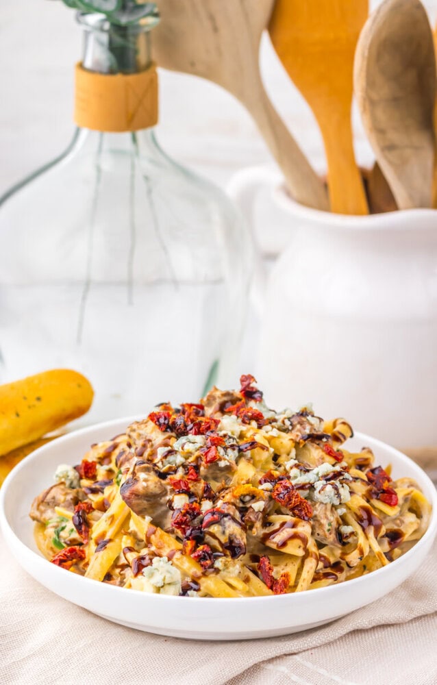 Slow Cooker Copycat Olive Garden Steak Gorgonzola pasta with mushrooms and sun-dried tomatoes on a white plate