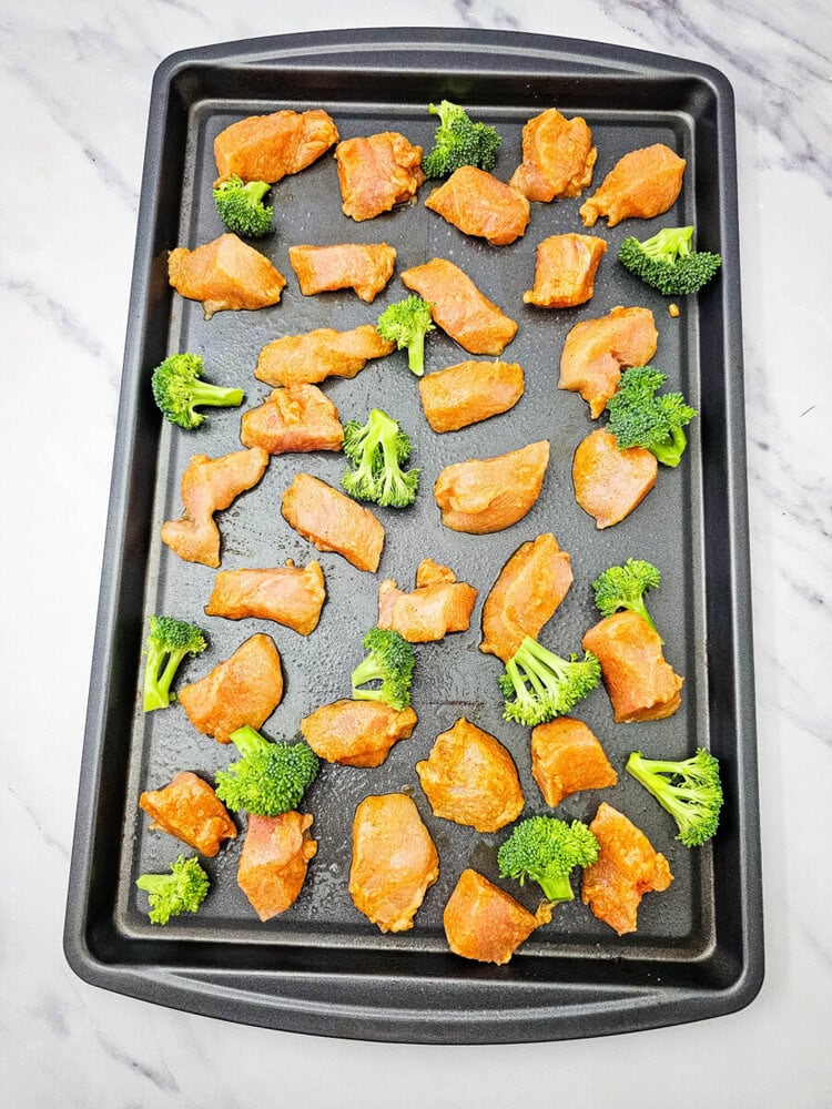 Sheet pan cashew chicken with golden-brown chicken pieces and fresh broccoli florets ready to serve