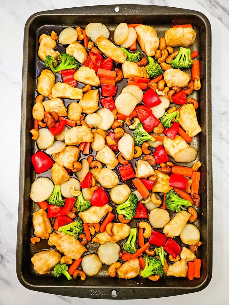 Sheet pan cashew chicken with roasted vegetables and nuts ready to serve