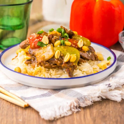 Slow cooker Kung Pao beef served over rice with peanuts and corn, plated and ready to serve