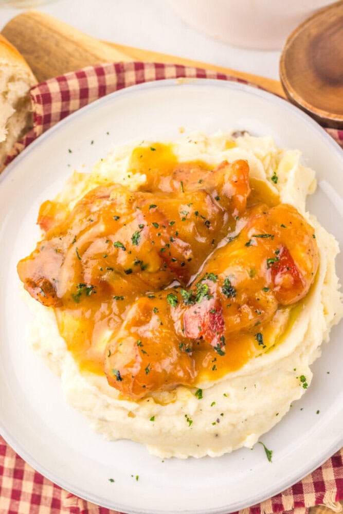 Slow cooker maple bacon chicken with mashed potatoes and egg yolk, garnished with parsley
