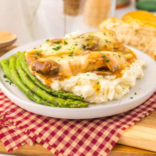 Slow cooker smothered chicken with mashed potatoes and asparagus plated and ready to serve