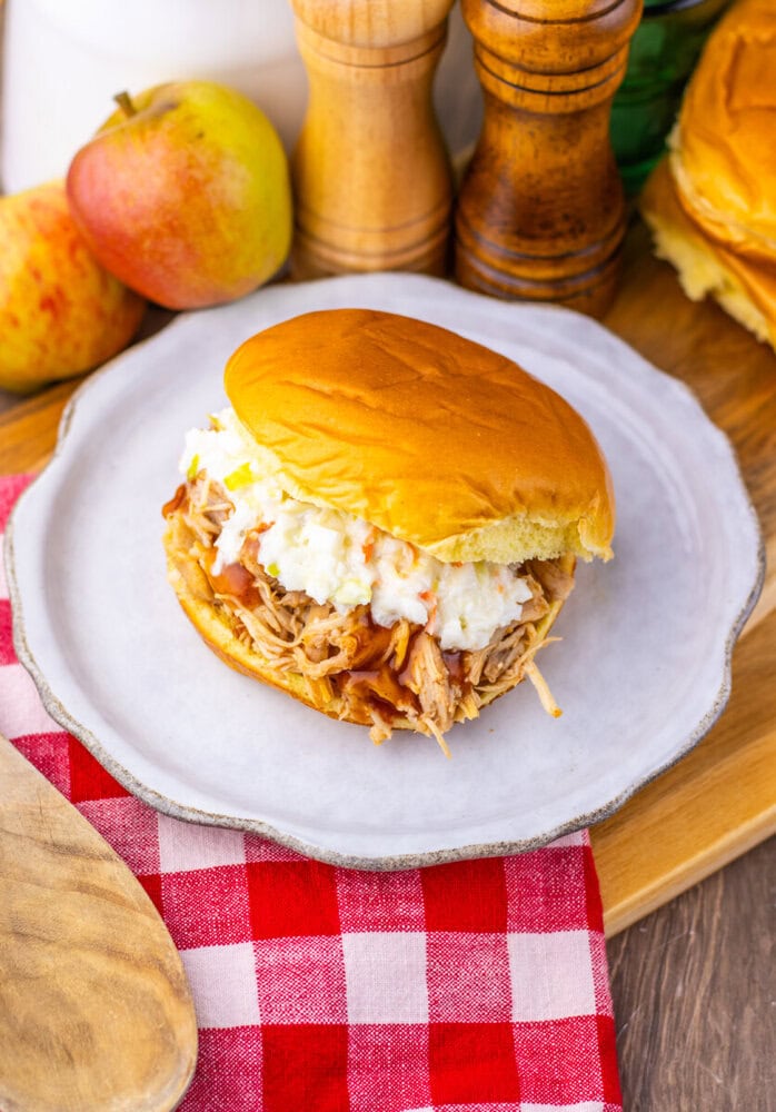 Apple cider BBQ pulled chicken sandwich with coleslaw on brioche bun, plated and ready to serve