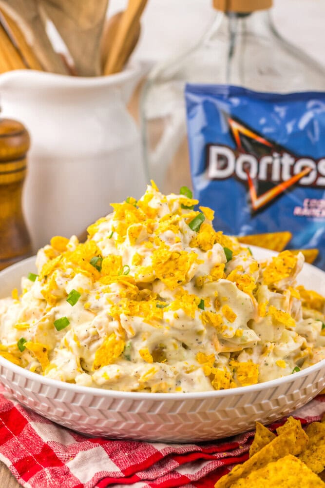 Cool Ranch Dorito Potato Salad in white bowl topped with crushed Doritos and green onions, ready to serve