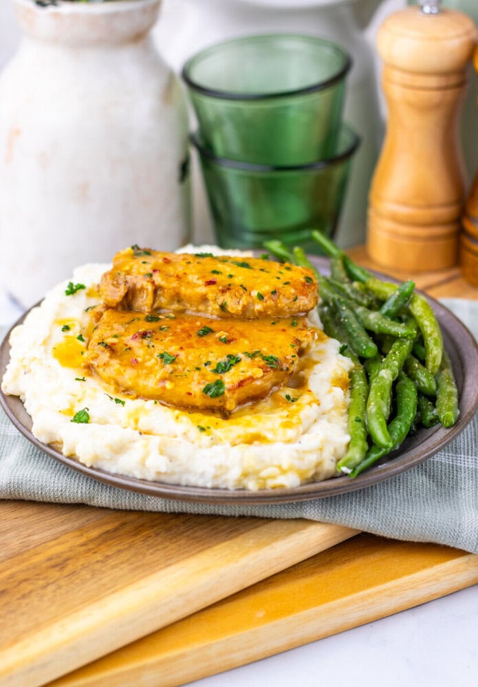 Maple Dijon pork chops served over mashed potatoes with roasted green beans