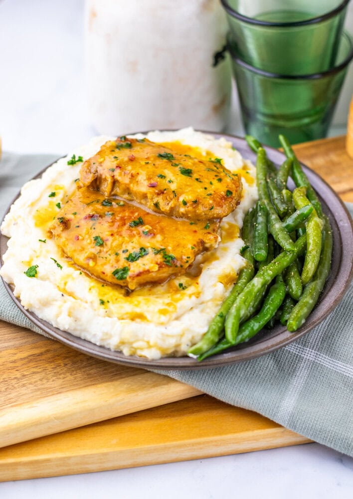 Maple Dijon pork chops served over mashed potatoes with roasted green beans