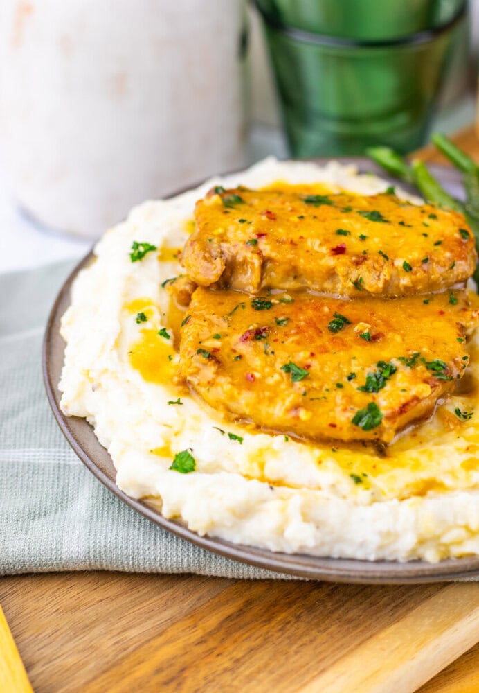 Maple Dijon pork chops served on mashed potatoes with parsley garnish