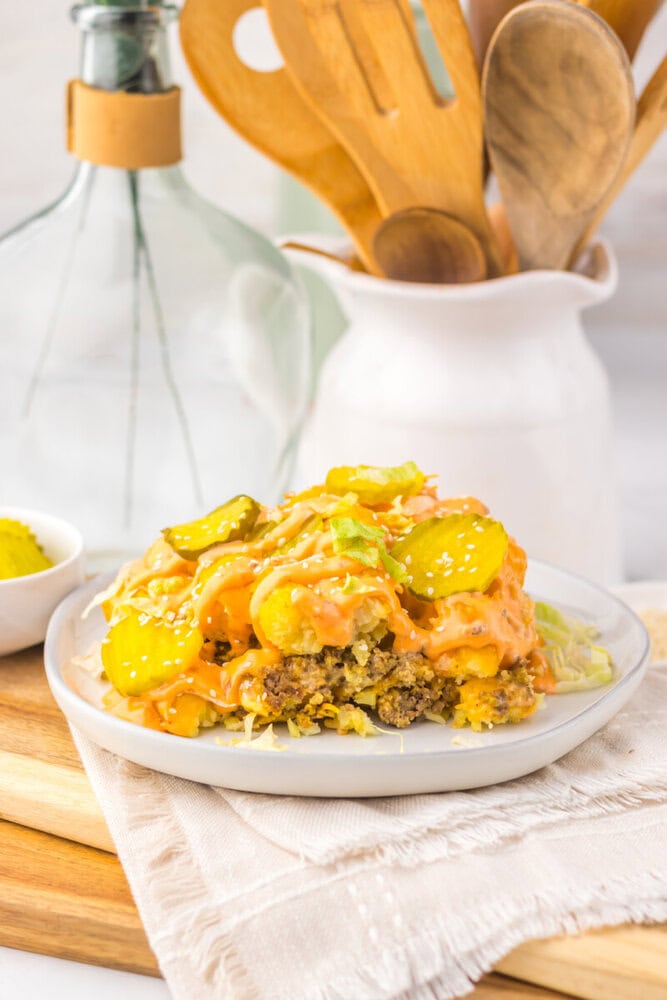 Slow Cooker Big Mac Tater Tot Casserole plated on white dish with golden tater tots and melted cheese