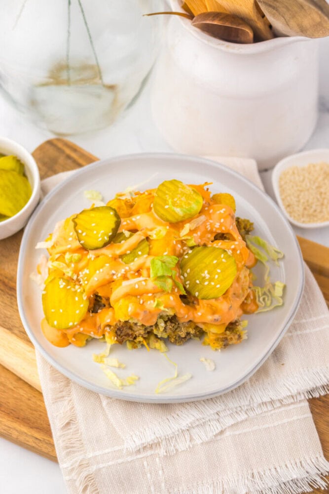 Slow Cooker Big Mac Tater Tot Casserole with melted cheese and pickles on white plate
