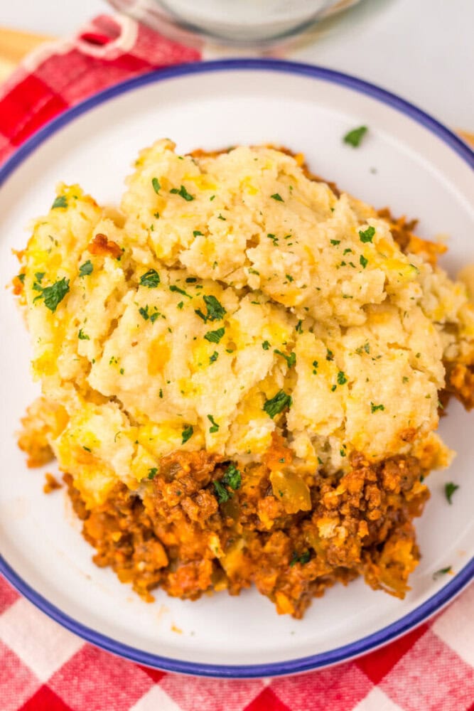 Slow Cooker Cheddar Bay Sloppy Joe Bake with mashed potato topping and parsley garnish on white plate