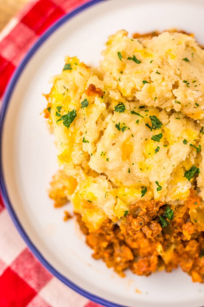 Slow Cooker Cheddar Bay Sloppy Joe Bake with mashed potato topping and parsley garnish on white plate