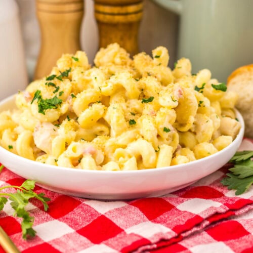 Slow cooker chicken cordon bleu pasta with creamy sauce and parsley garnish served on white plate