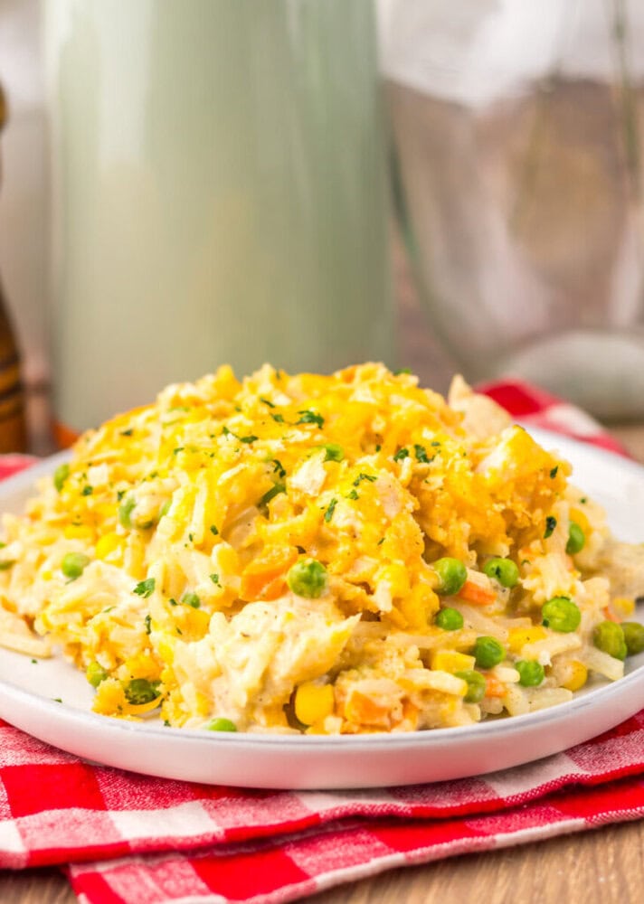 Slow cooker chicken pot pie hash brown casserole with corn, peas, and green onions on white plate