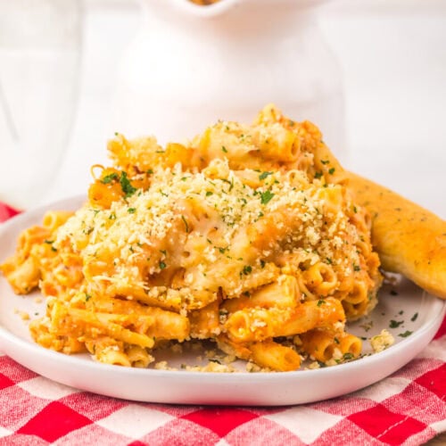 Slow Cooker Five Cheese Ziti Al Forno with golden breadcrumb topping and breadstick on white plate