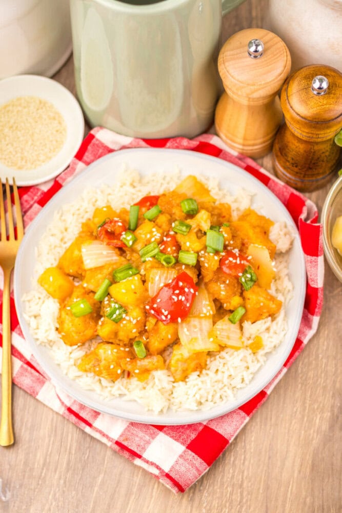 Slow Cooker Copycat Panda Express Sweet Fire Chicken served over rice with sesame seeds and green onion garnish