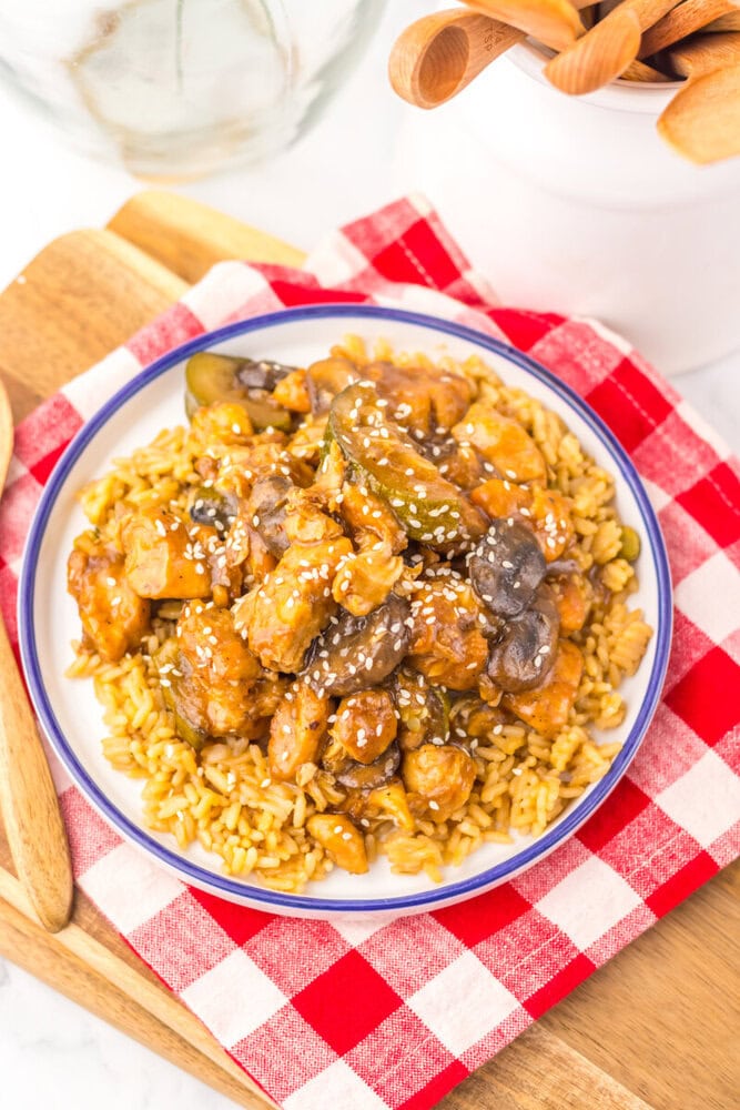 Slow cooker panda express mushroom chicken over rice noodles garnished with sesame seeds