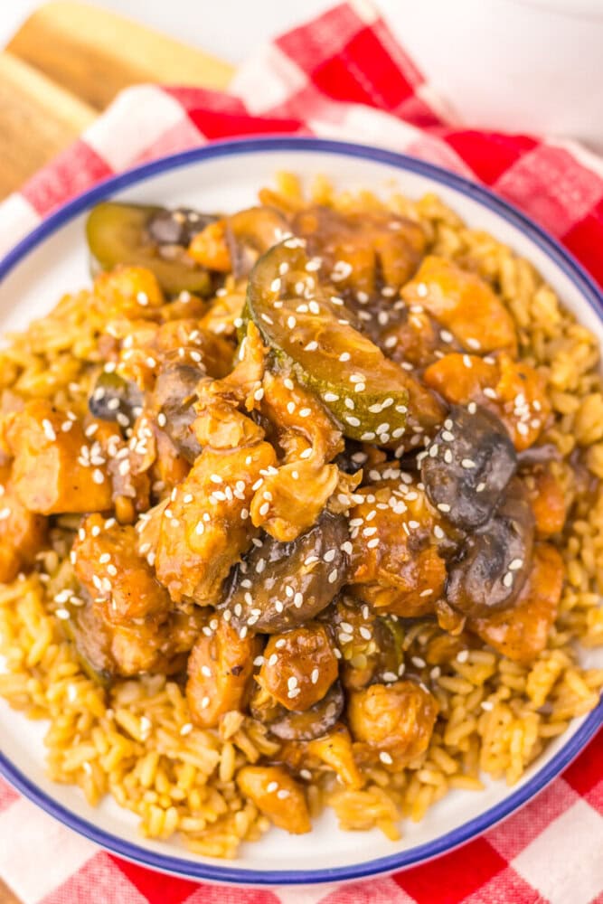 Slow cooker copycat Panda Express mushroom chicken with sesame seeds served over yellow rice