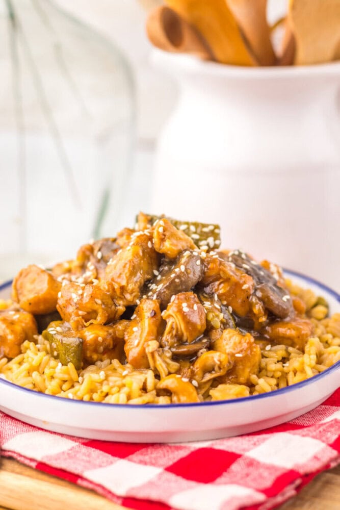 Slow cooker mushroom chicken over rice garnished with sesame seeds, plated and ready to serve