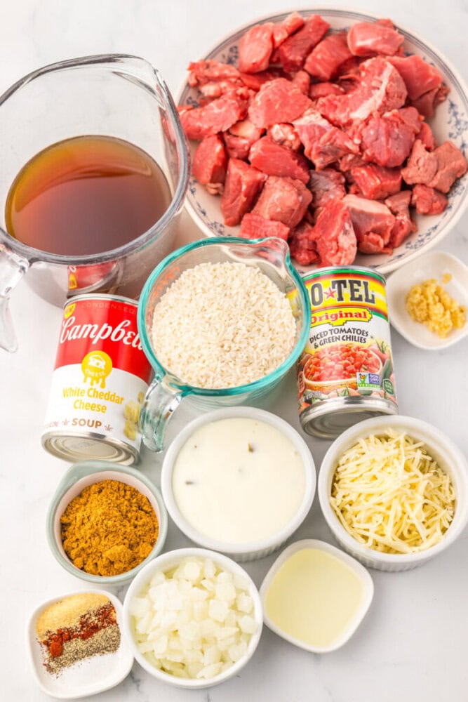 Slow cooker queso steak and rice ingredients laid out flat lay overhead view
