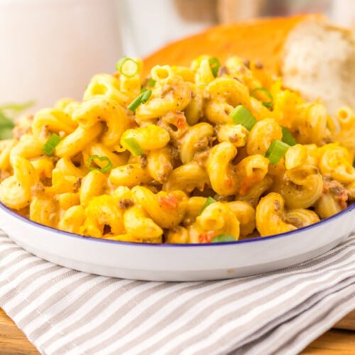 Slow cooker Rotel pasta with cheese sauce and green onion garnish plated and ready to serve