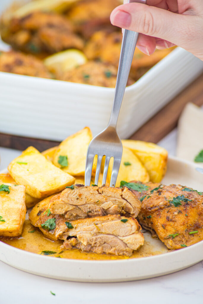 Oven baked boneless skinless chicken thighs sliced and plated with roasted potatoes and herbs