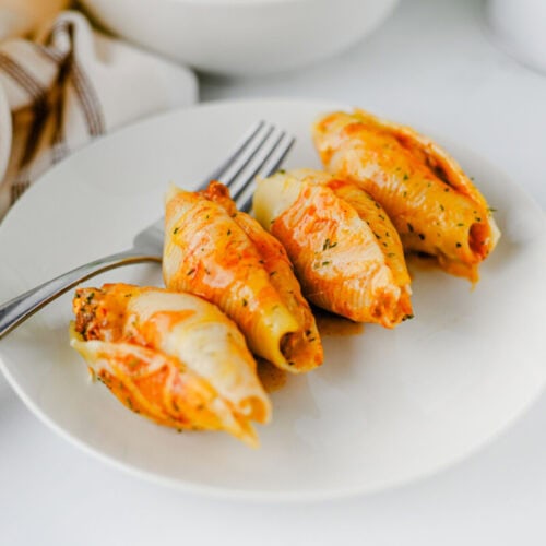 Cheesy taco stuffed shells plated and ready to eat on white dinnerware