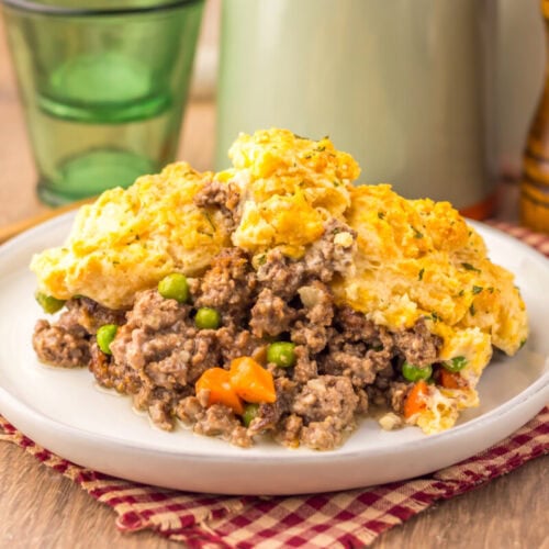 Cheddar Bay Beef Cobbler with ground beef filling and cheese biscuit topping on a white plate
