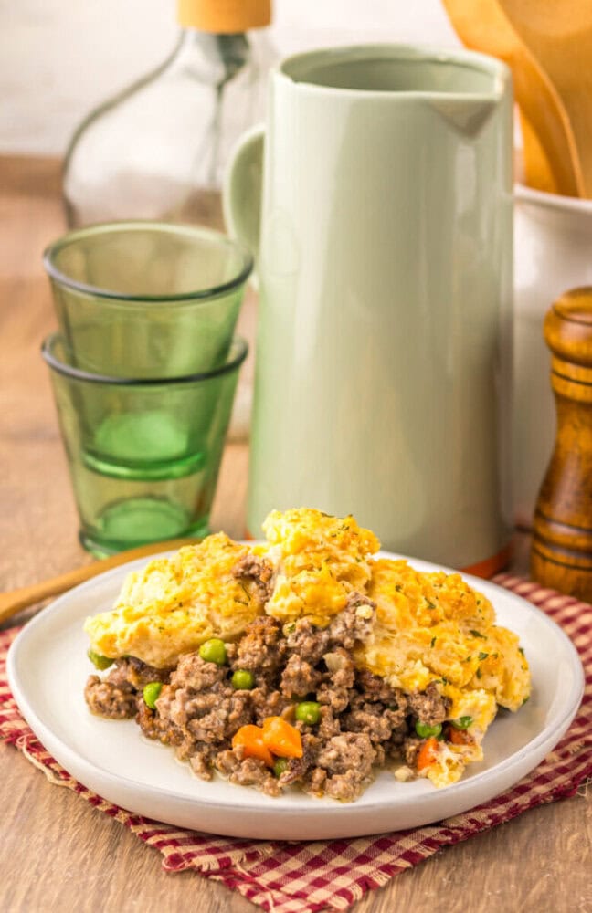Cheddar Bay Beef Cobbler with ground beef, peas, carrots, and golden cheddar biscuit topping on white plate