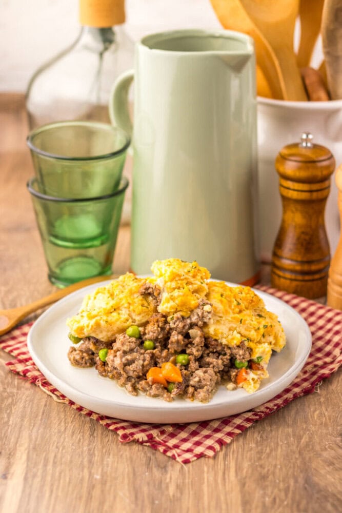Cheddar Bay Beef Cobbler with golden biscuits and ground beef filling on white plate