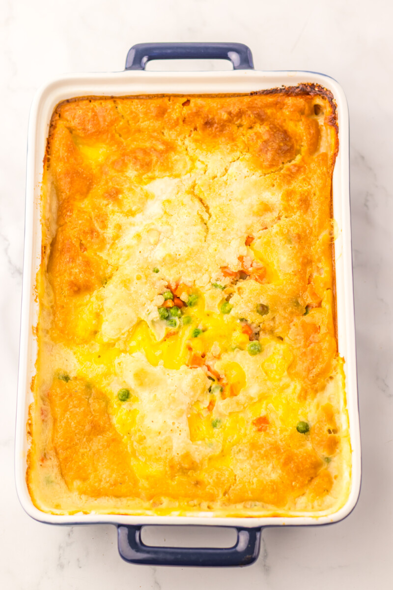 Baked chicken cobbler with golden biscuit topping and mixed vegetables in a rectangular baking dish