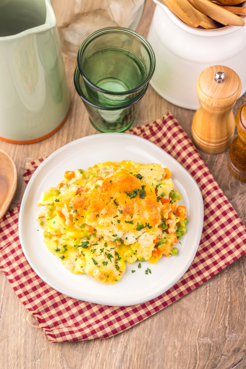 Golden omelet with peppers and peas garnished with fresh herbs on white plate