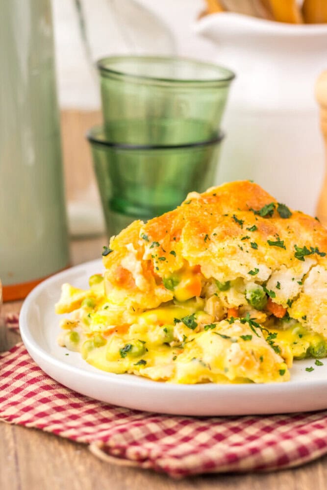 Cooked omelet with cheese and peas garnished with parsley on white plate